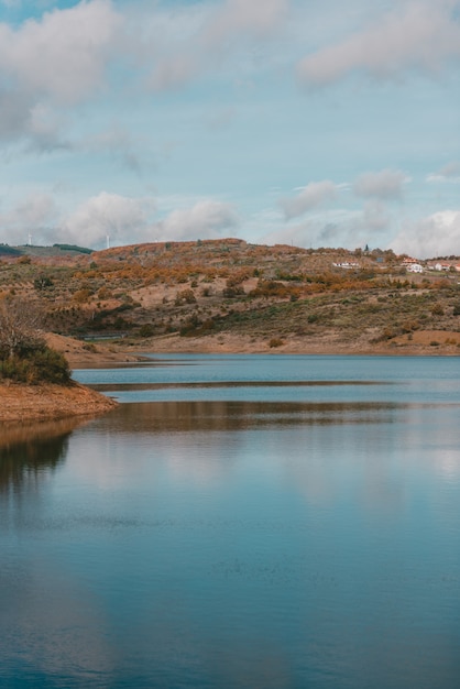 Bellissimo lago circondato da una catena montuosa sotto il cielo nuvoloso mozzafiato