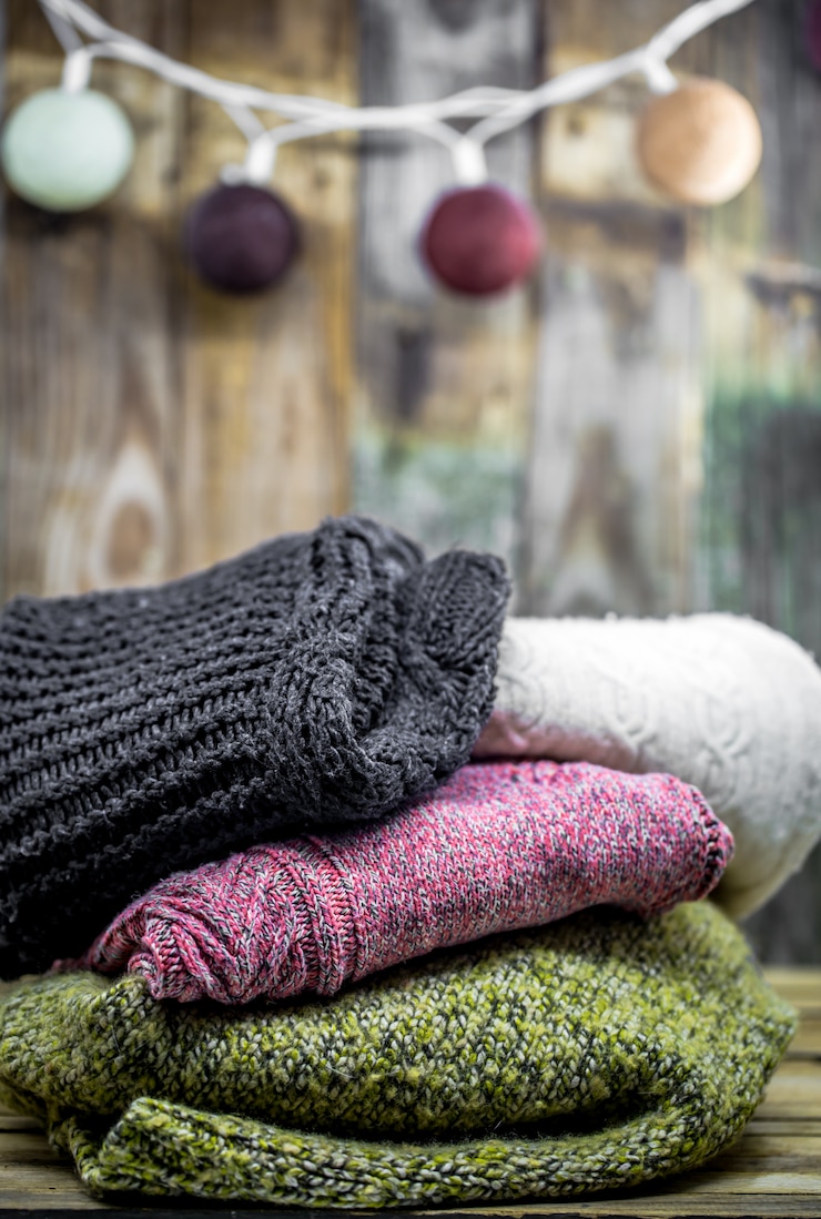 Foto gratuito bellissimo maglione caldo accogliente su un legno