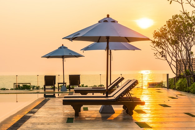 Bellissimo ombrellone e sedia intorno alla piscina in hotel e resort