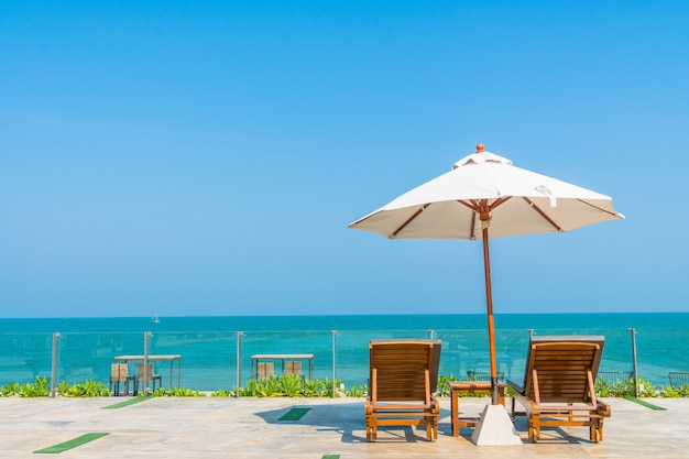 Bellissimo ombrellone e sedia intorno alla piscina in hotel e resort