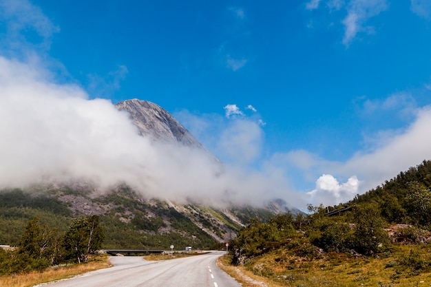 Bellissimo paesaggio con la strada tortuosa in montagna con nuvole