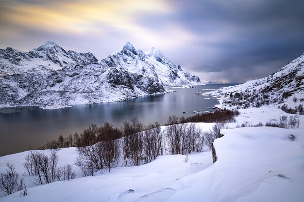 Bellissimo paesaggio invernale con montagne innevate e acqua ghiacciata