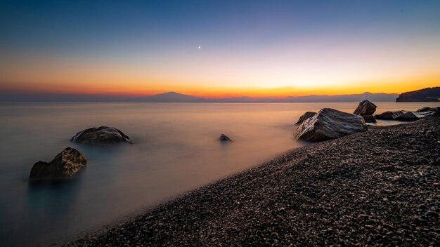 Bellissimo paesaggio marino al tramonto con formazioni rocciose nell'acqua