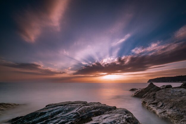 Bellissimo paesaggio marino al tramonto con formazioni rocciose nell'acqua