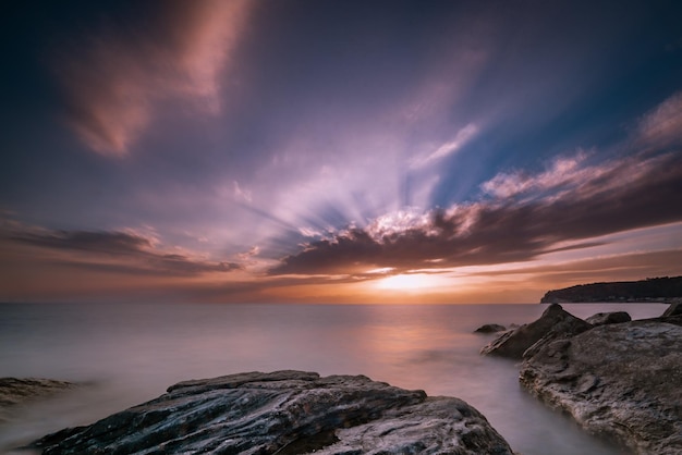 Bellissimo paesaggio marino al tramonto con formazioni rocciose nell'acqua