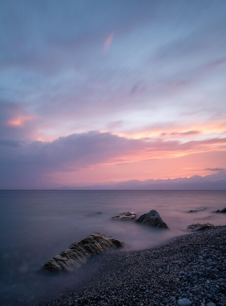 Bellissimo paesaggio marino al tramonto con formazioni rocciose nell'acqua