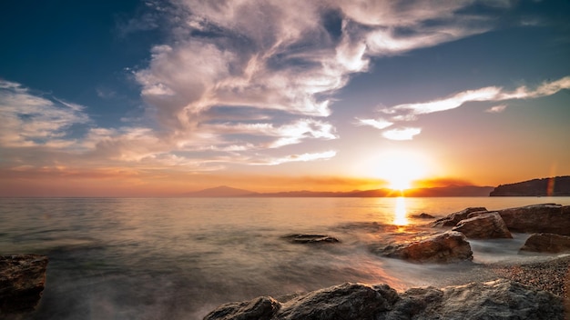 Bellissimo paesaggio marino al tramonto con formazioni rocciose nell'acqua