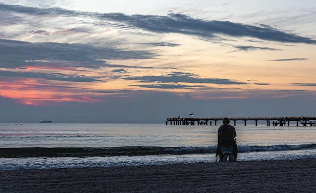 Bellissimo paesaggio marino con un ponte al tramonto