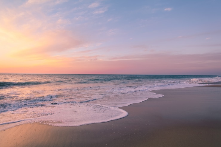 Foto gratuito bellissimo scatto del colorato tramonto in spiaggia
