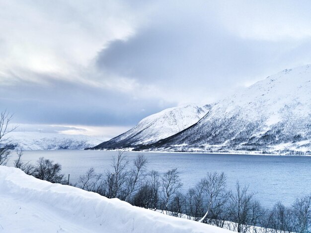 Bellissimo scatto del lago ghiacciato Kattfjordvatnet e delle montagne innevate in Norvegia