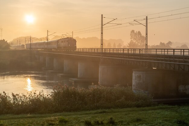 Bellissimo scatto del treno che passa su un ponte in una giornata di sole