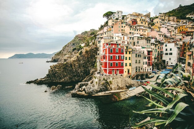 Bellissimo scatto di edifici dai colori assortiti sulla collina vicino al mare a Manarola, Italia