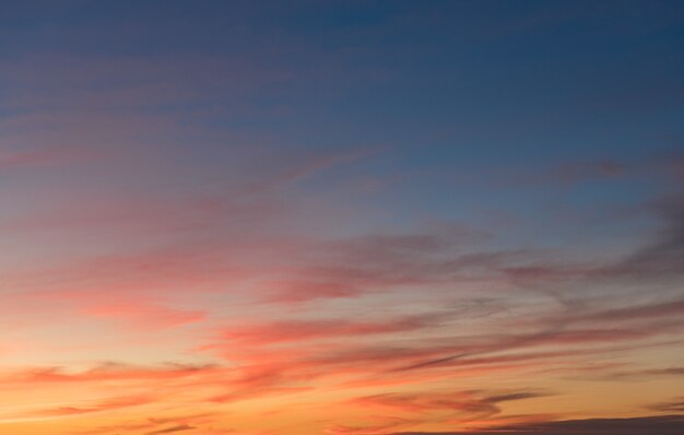 Bellissimo scatto di nuvole rosa in un cielo azzurro e limpido con uno scenario di alba