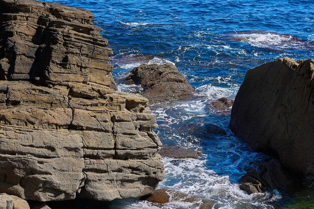 Bellissimo scatto di pietra nel mare con onda