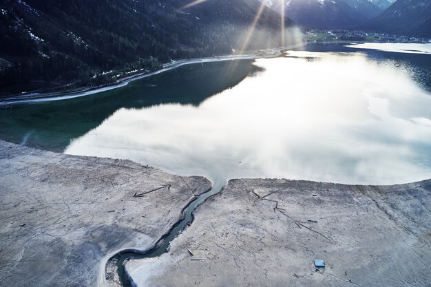 Bellissimo scatto di un lago con il riflesso del cielo e una crepa sulla riva