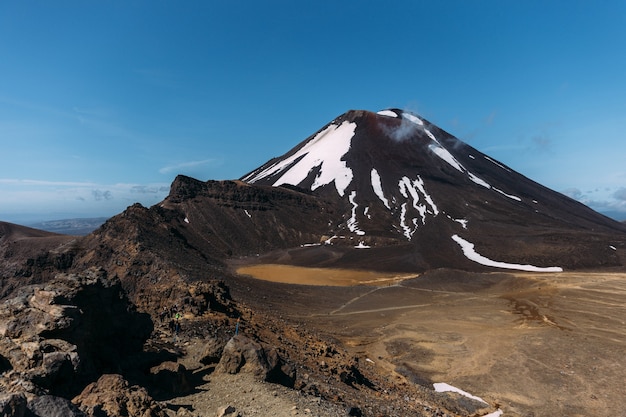 Bellissimo scatto di un paesaggio roccioso con colline sullo sfondo sotto un cielo azzurro