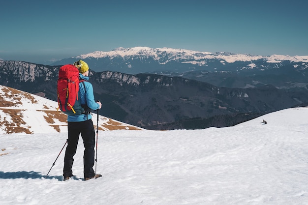 Bellissimo scatto di un uomo che fa un'escursione nelle montagne innevate dei Carpazi in Romania