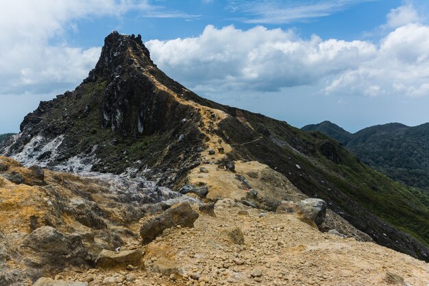 Bellissimo scatto di una montagna sotto un cielo nuvoloso blu