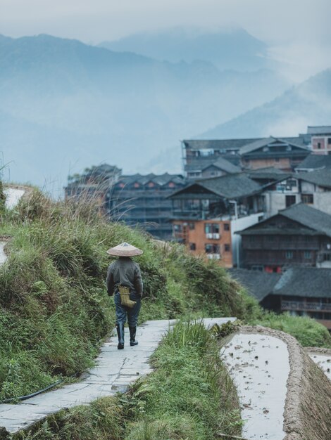 Bellissimo scatto di una persona che cammina lungo un sentiero di tono di una terrazza in una città cinese