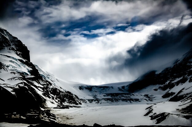 Bellissimo scenario di un paesaggio montuoso con montagne rocciose coperte di neve sotto la luce del sole