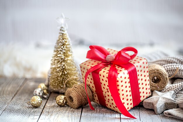 Bellissimo sfondo di Natale con giocattoli di Natale e una confezione regalo con un fiocco rosso. Il concetto di saluti e feste di Capodanno.