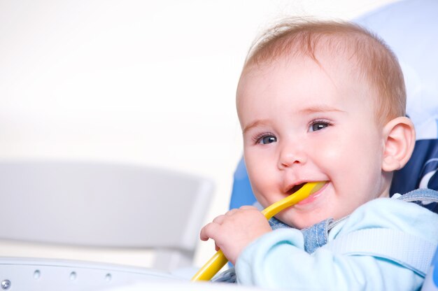 Bello bambino felice con il cucchiaio