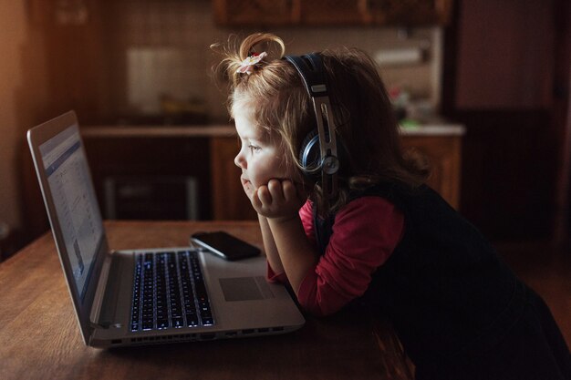 Bello bambino felice in cuffie che ascolta la musica.