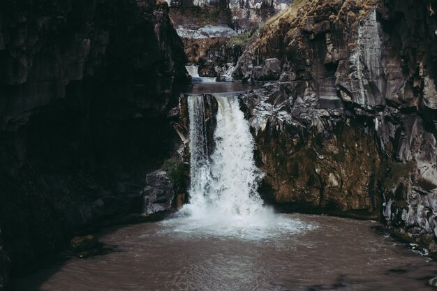 Bello colpo di acqua che scorre giù in uno stagno in mezzo alle scogliere