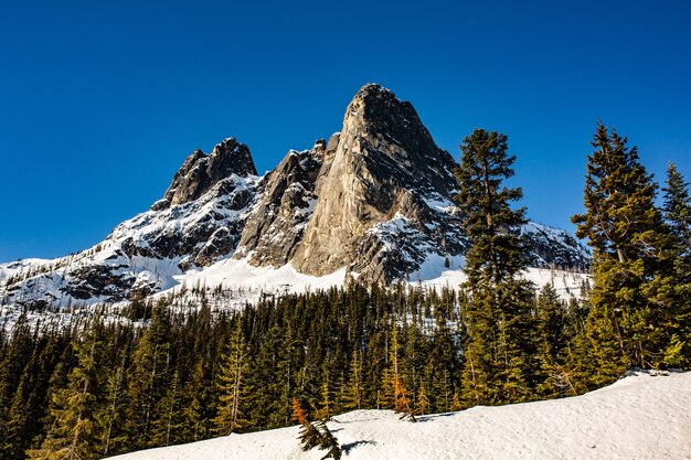 Bello colpo di alte montagne rocciose e colline coperte di neve rimanente in primavera