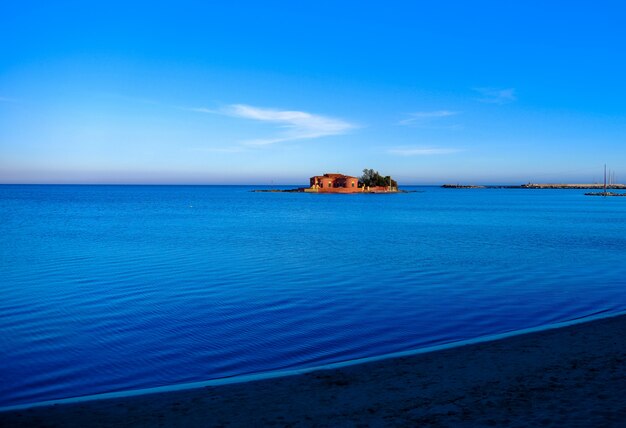 Bello colpo di una grande casa in mezzo al mare sotto un cielo blu