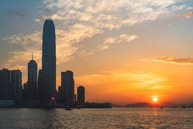 Bello colpo di uno skyline urbano della città con il mare sul lato al tramonto