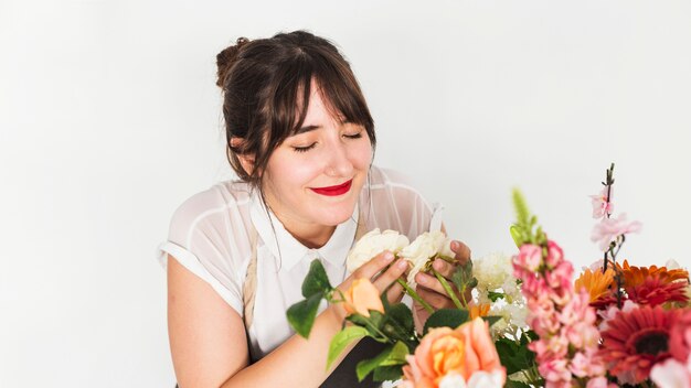 Bello fiorista femminile che sente l&#39;odore dei fiori