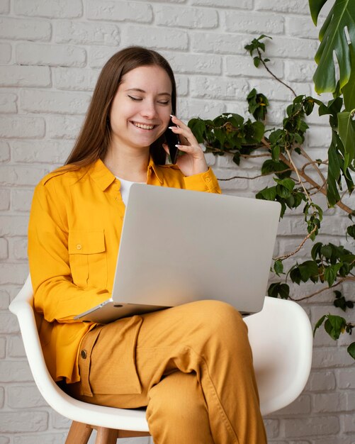 Bello giardiniere femminile che lavora al suo computer portatile