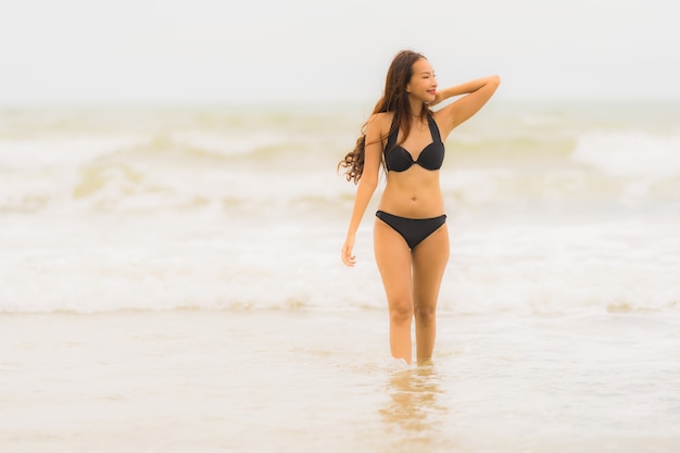 Bello giovane bikini asiatico di usura di donna del ritratto sull&#39;oceano del mare della spiaggia