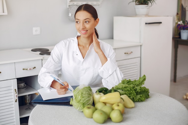 Bello medico in una cucina con verdure