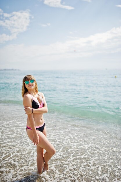 Bello modello che si distende su una spiaggia vestito con un costume da bagno