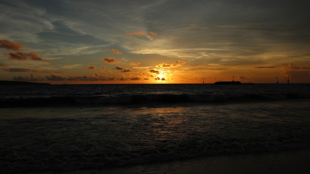 Bello paesaggio alla spiaggia con il tramonto e le nuvole in Bali, Indonesia