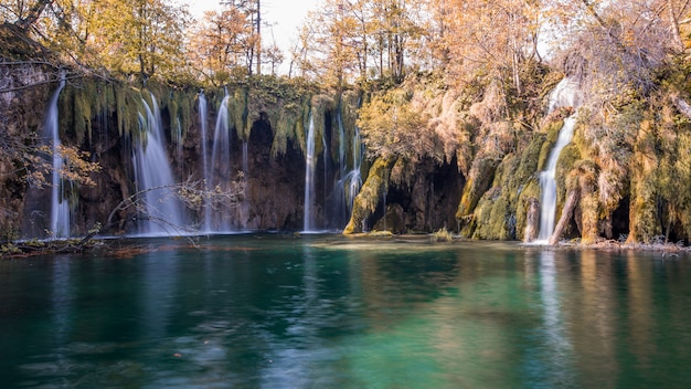 Bello paesaggio sparato di un lago scenico con le cascate che sfociano in Plitvice, Croazia