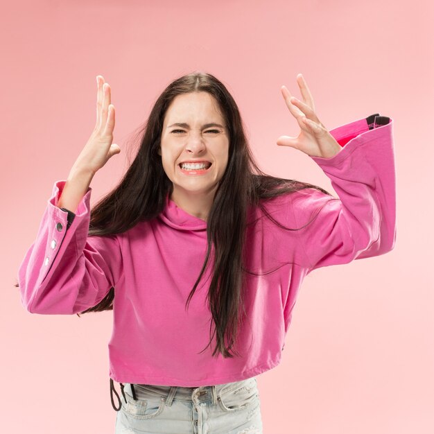 Bello ritratto a mezzo busto femminile isolato sul backgroud rosa alla moda dello studio.