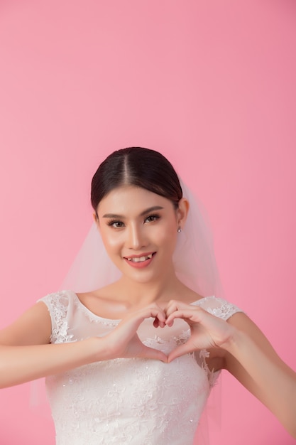 Bello ritratto asiatico della sposa nel rosa