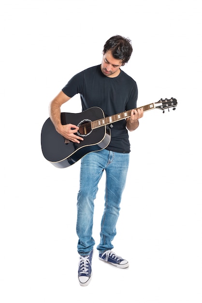 Bello uomo con chitarra su sfondo bianco