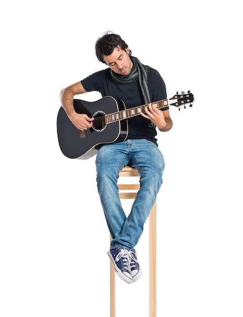 Bello uomo con chitarra su sfondo bianco