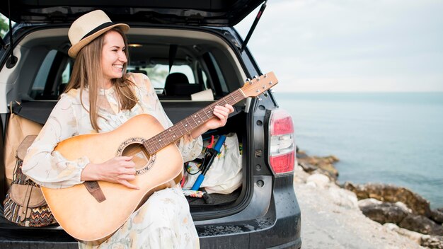 Bello viaggiatore che suona la chitarra in vacanza