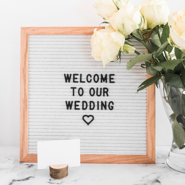 Benvenuti al nostro messaggio di matrimonio su telaio in legno con biglietto da visita in bianco e rose