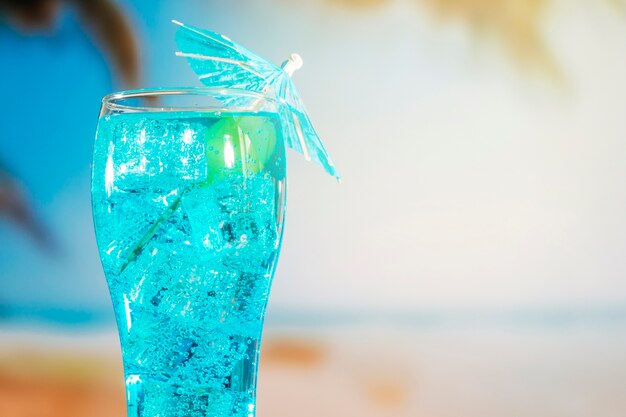 Bevanda blu con cubetti di ghiaccio in vetro decorato a ombrello