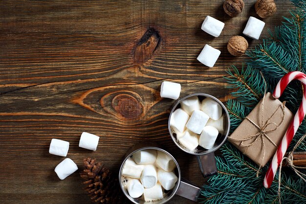 Bevanda calda di Natale. Cacao con rami di marshmallow, cioccolato e abete su fondo di legno. Nuovo anno 2018