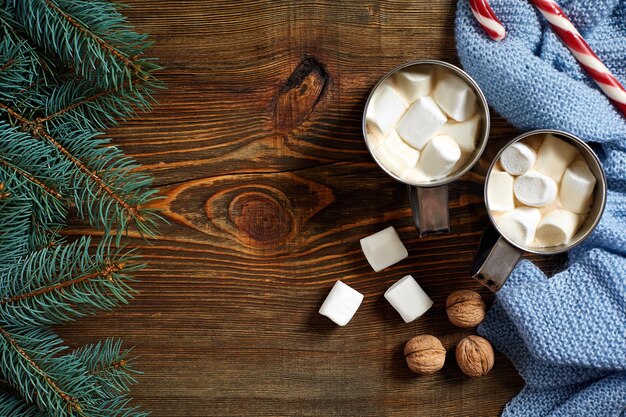 Bevanda di Natale. Tazza di caffè caldo con marshmallow, bastoncino di zucchero rosso sullo sfondo di legno. Capodanno. Carta di vacanza. Stile rustico. Vista dall'alto e spazio per la copia. Nuovo anno 2018