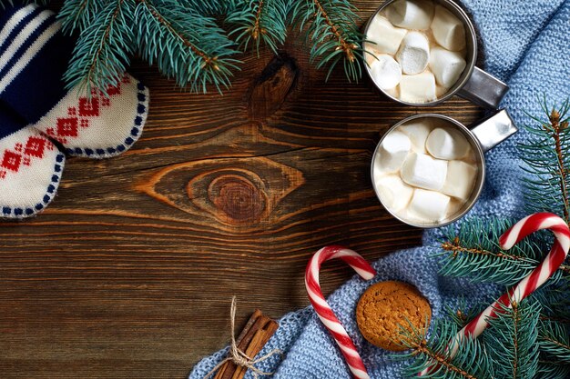 Bevanda di Natale. Tazza di caffè caldo con marshmallow, bastoncino di zucchero rosso sullo sfondo di legno. Capodanno. Carta di vacanza. Stile rustico. Vista dall'alto e spazio per la copia. Nuovo anno 2018