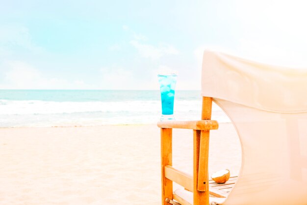 Bevanda luminosa blu sul braccio della sedia e della noce di cocco di legno