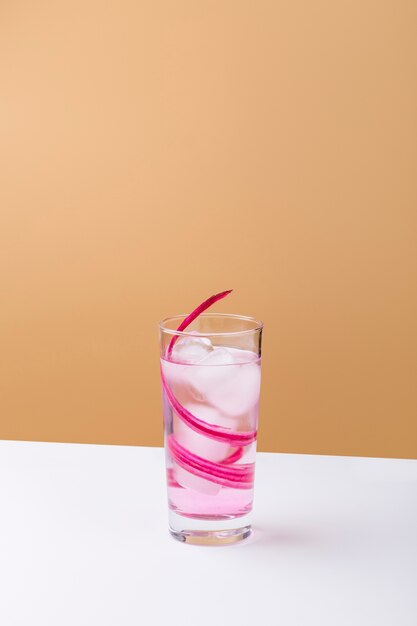 Bevanda rosa saporita con i cubetti di ghiaccio sulla tavola bianca